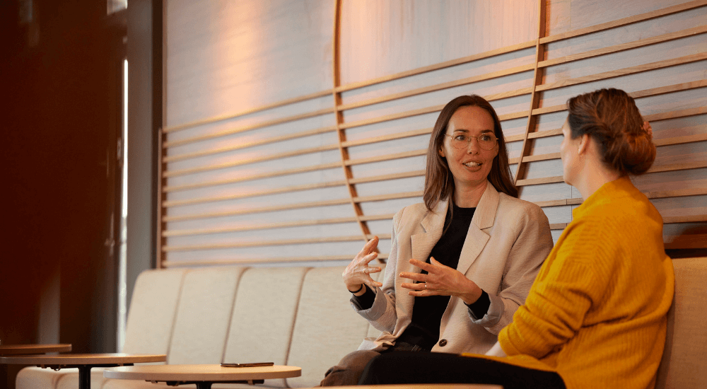 To kvinder sidder i sofa og taler