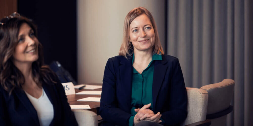 Hvilke kurser skal jeg vælge - ledelse: kvindelig kursist sidder og lytter og smiler