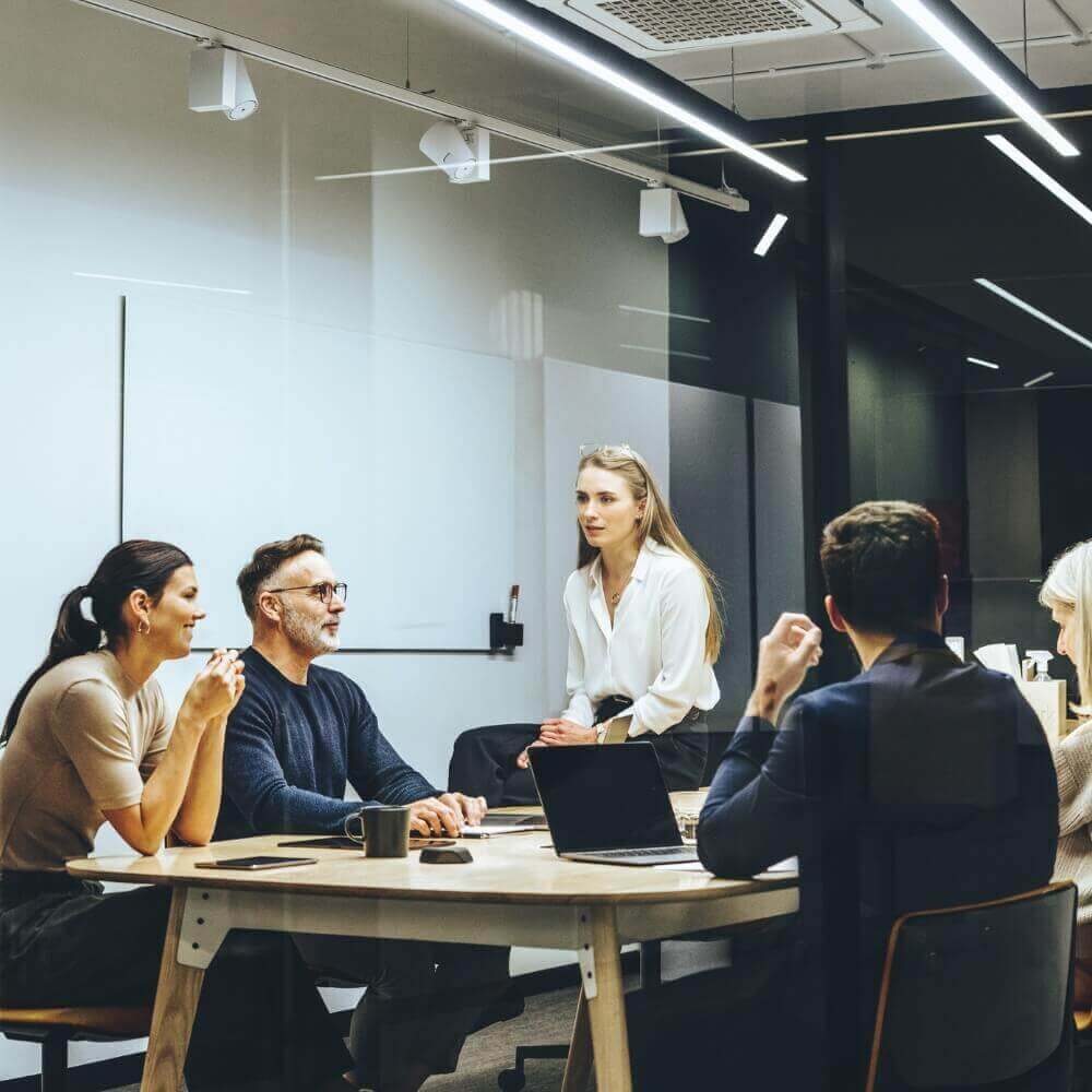 Lederuddannelse: Personer om et bord i et mødelokale