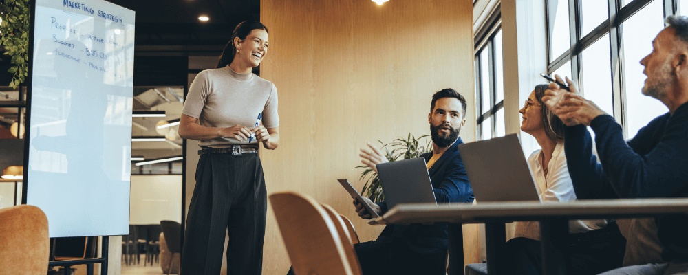 Ledelseskurser for alle: kvindelig underviser med kursister - griner